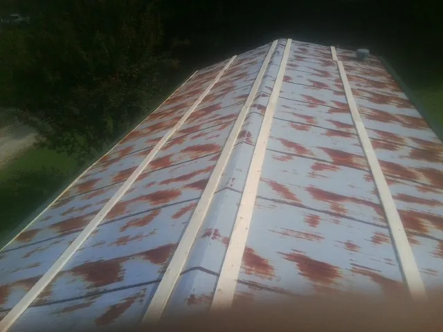 Rusted metal roof panels with new wood purlins before replacement — Storm Damage Roof Repair in Loyalhanna by Roofing Brothers