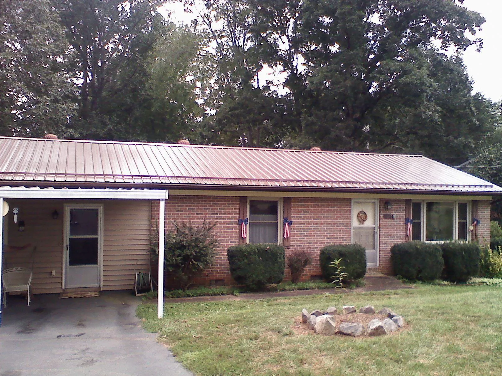 Bronze metal roof and carport on a brick ranch home — Roof Repair work by our crew in Loyalhanna